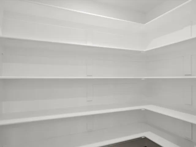 White shelving system with multiple levels, extending along two walls