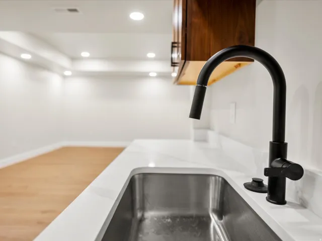 Stainless steel undermount sink with a matte black gooseneck faucet