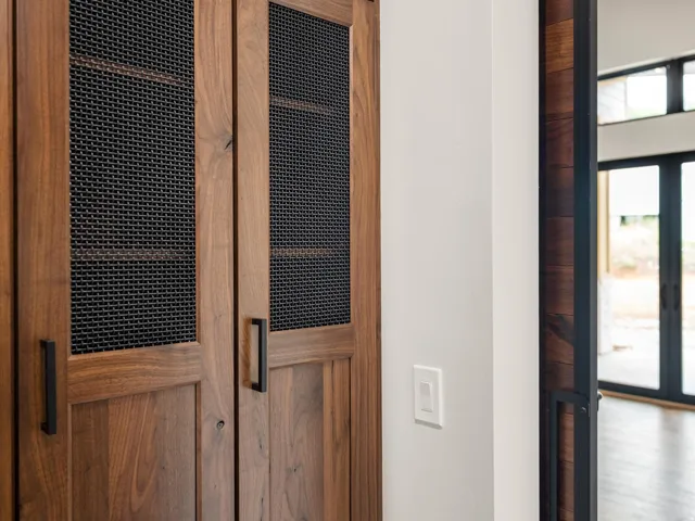 Wood-paneled doors with mesh inserts, complemented by matte black hardware