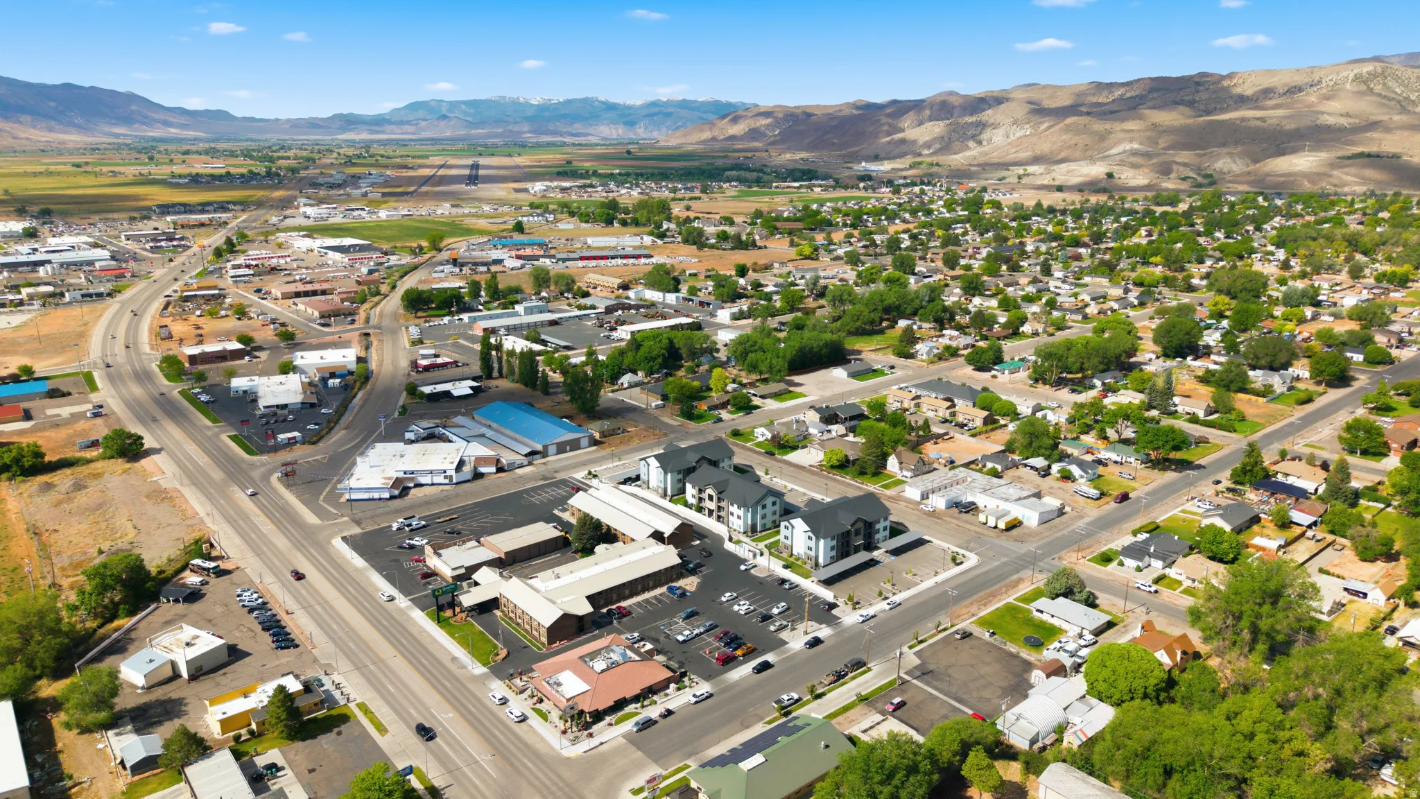 Expansive aerial overview showcasing a diverse neighborhood with residential areas and commercial establishments