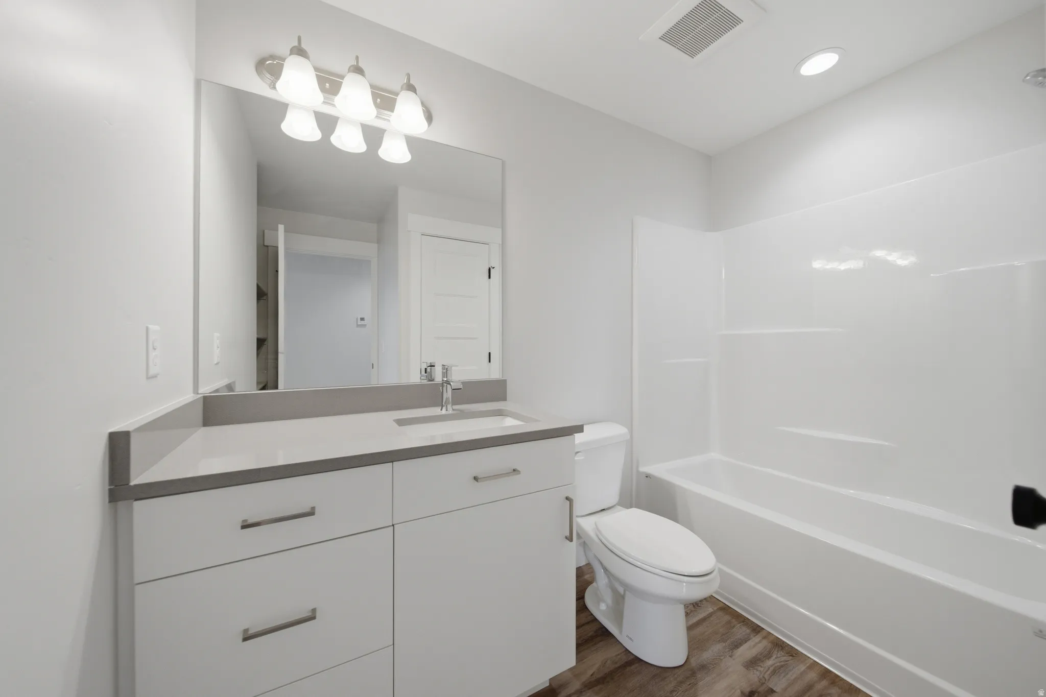 Bathroom featuring a white vanity with quartz countertop, undermount sink, and brushed nickel faucet