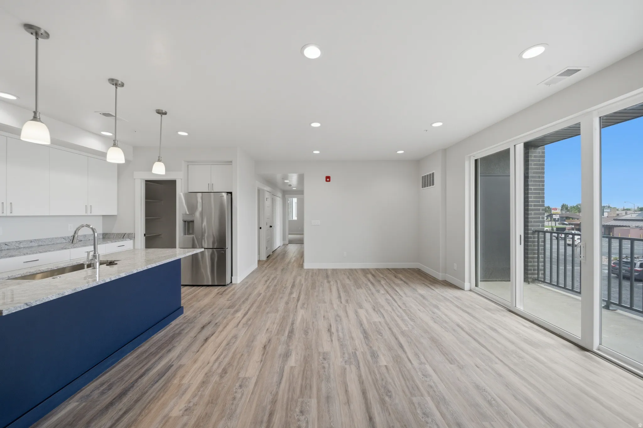 Open-concept living area featuring wood-finish flooring and recessed lighting