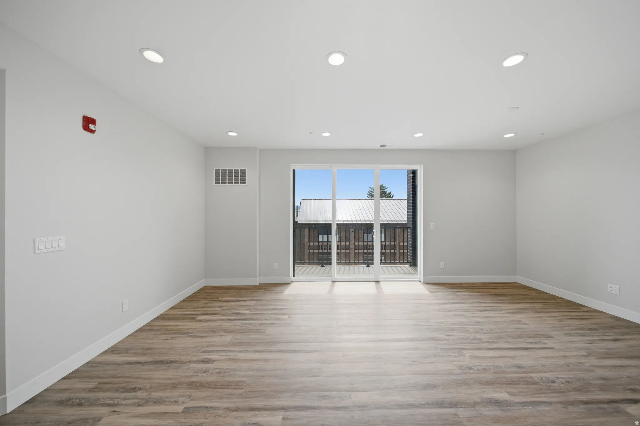 Spacious interior featuring wood-finish flooring, recessed ceiling lighting, and light-toned wall paint