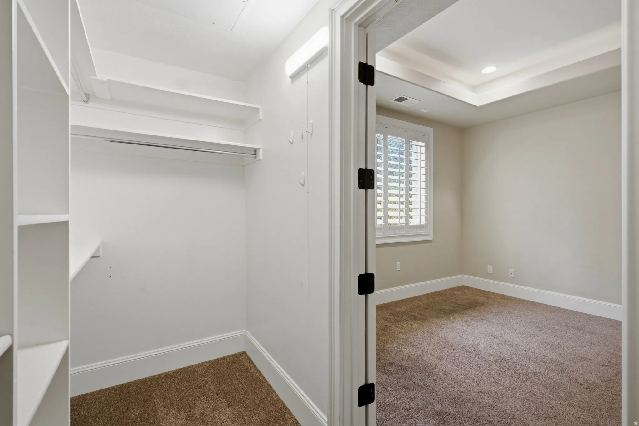 Walk-in closet with built-in shelving, hanging rod, and wall hooks