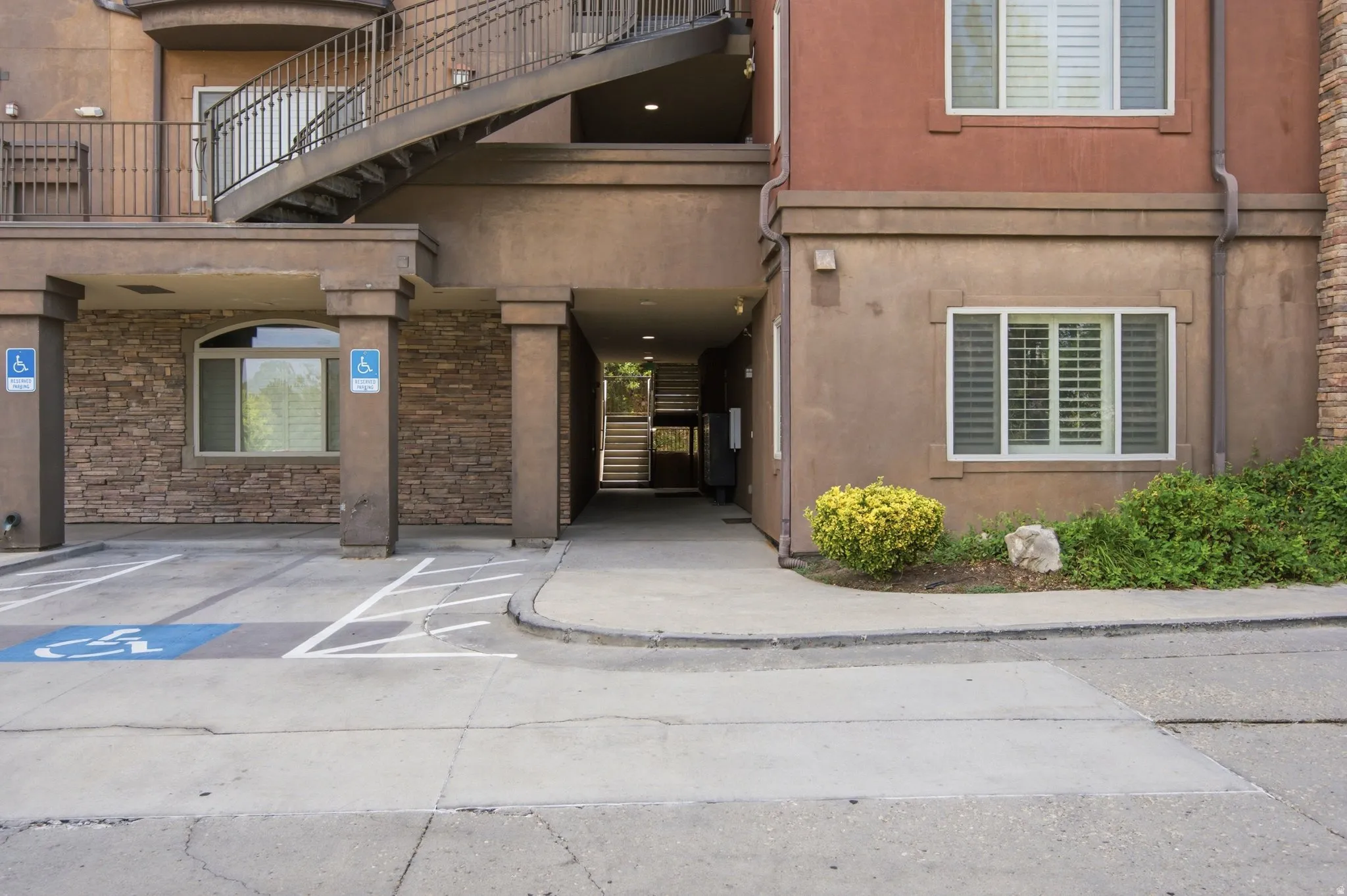 Exterior facade featuring multi-story construction with a concrete parking area