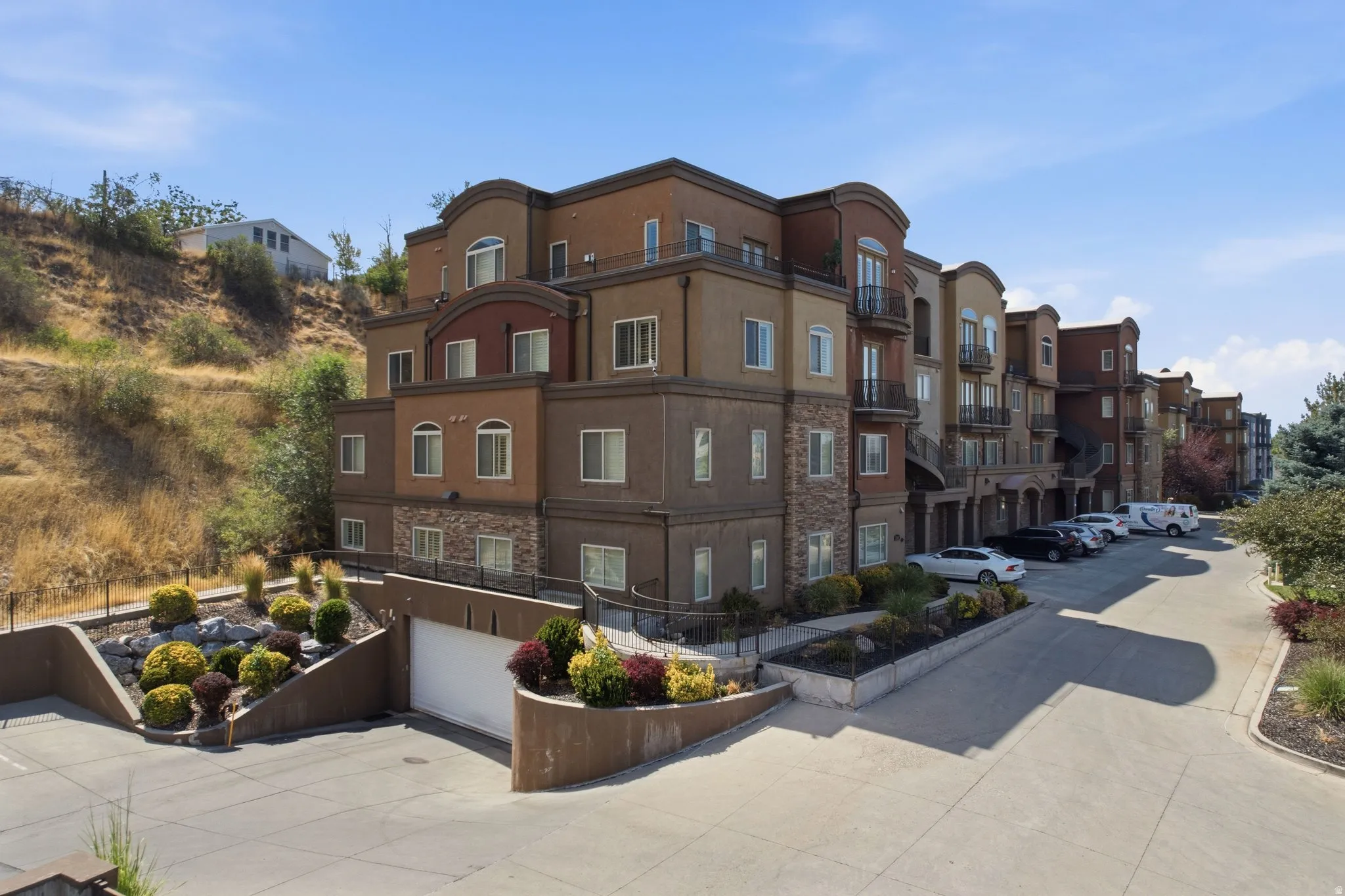 Multi-story residential building with varied earth-toned stucco and stone facade