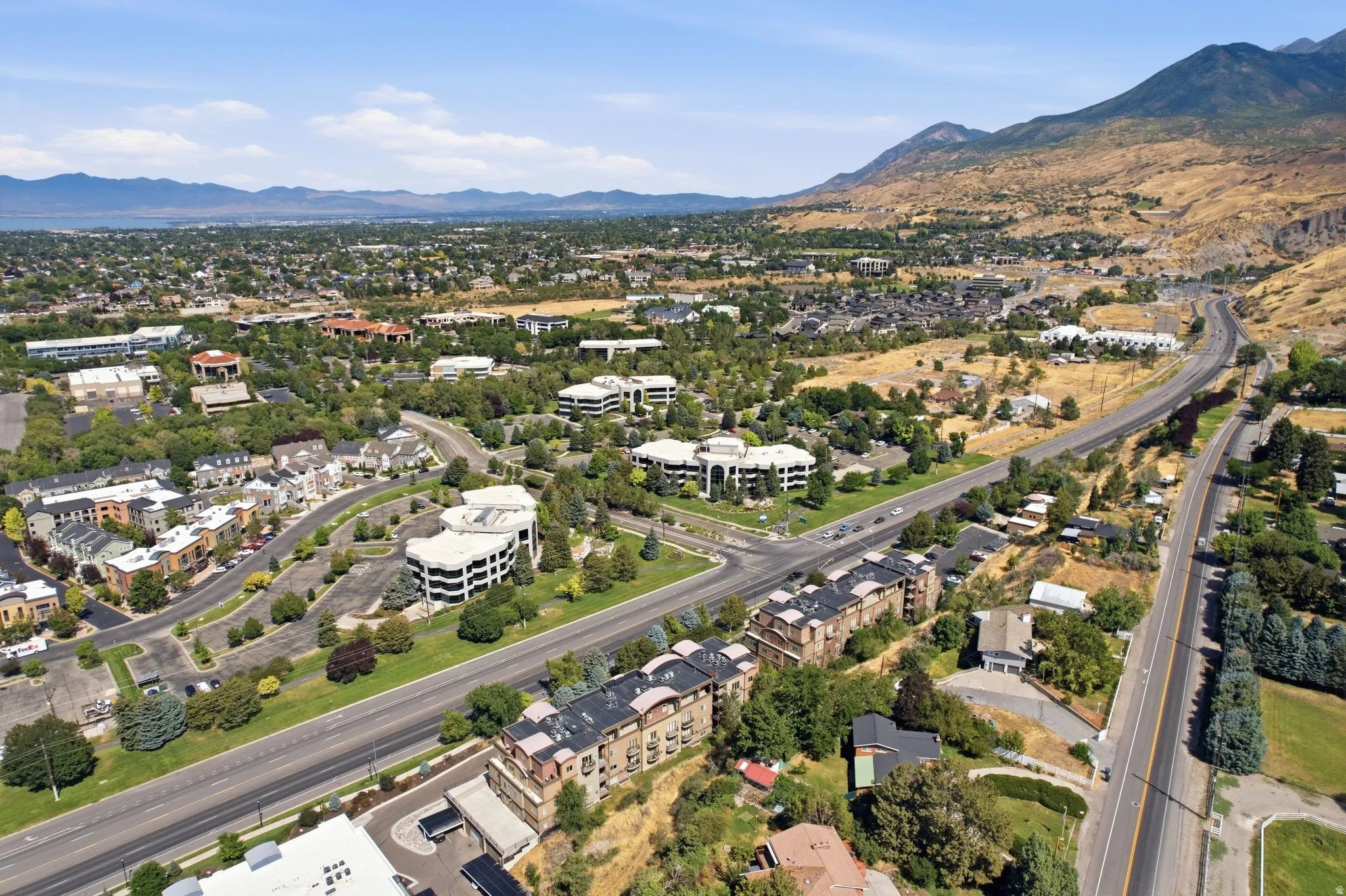 Aerial perspective showcasing a developed area with extensive greenery and mountainous terrain