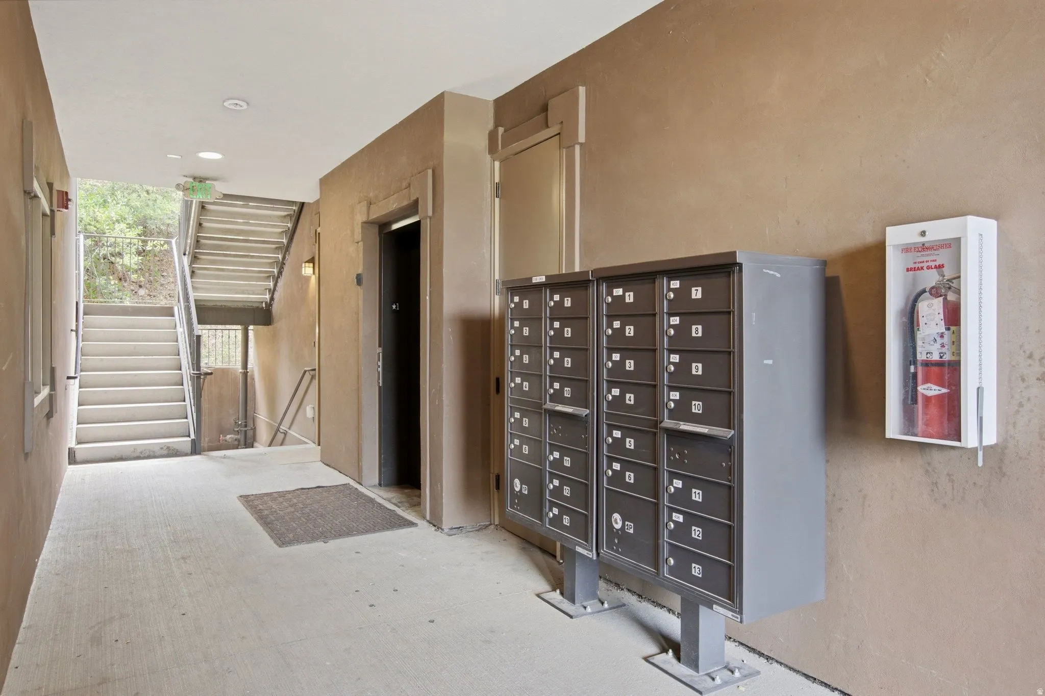 Mailboxes and fire extinguisher station within a textured wall corridor