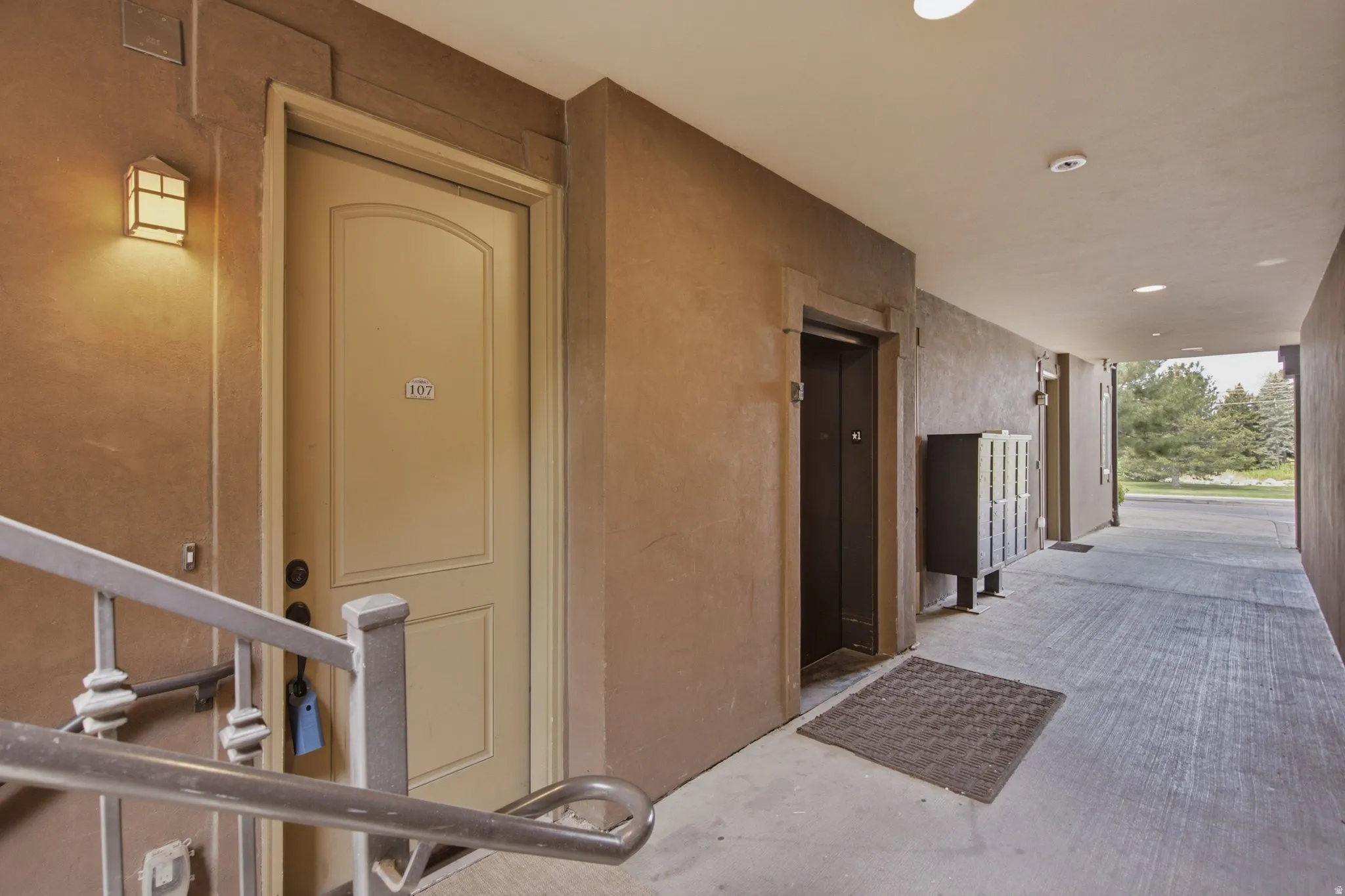 Corridor featuring textured walls, recessed lighting, and a neutral-toned door with panel detailing