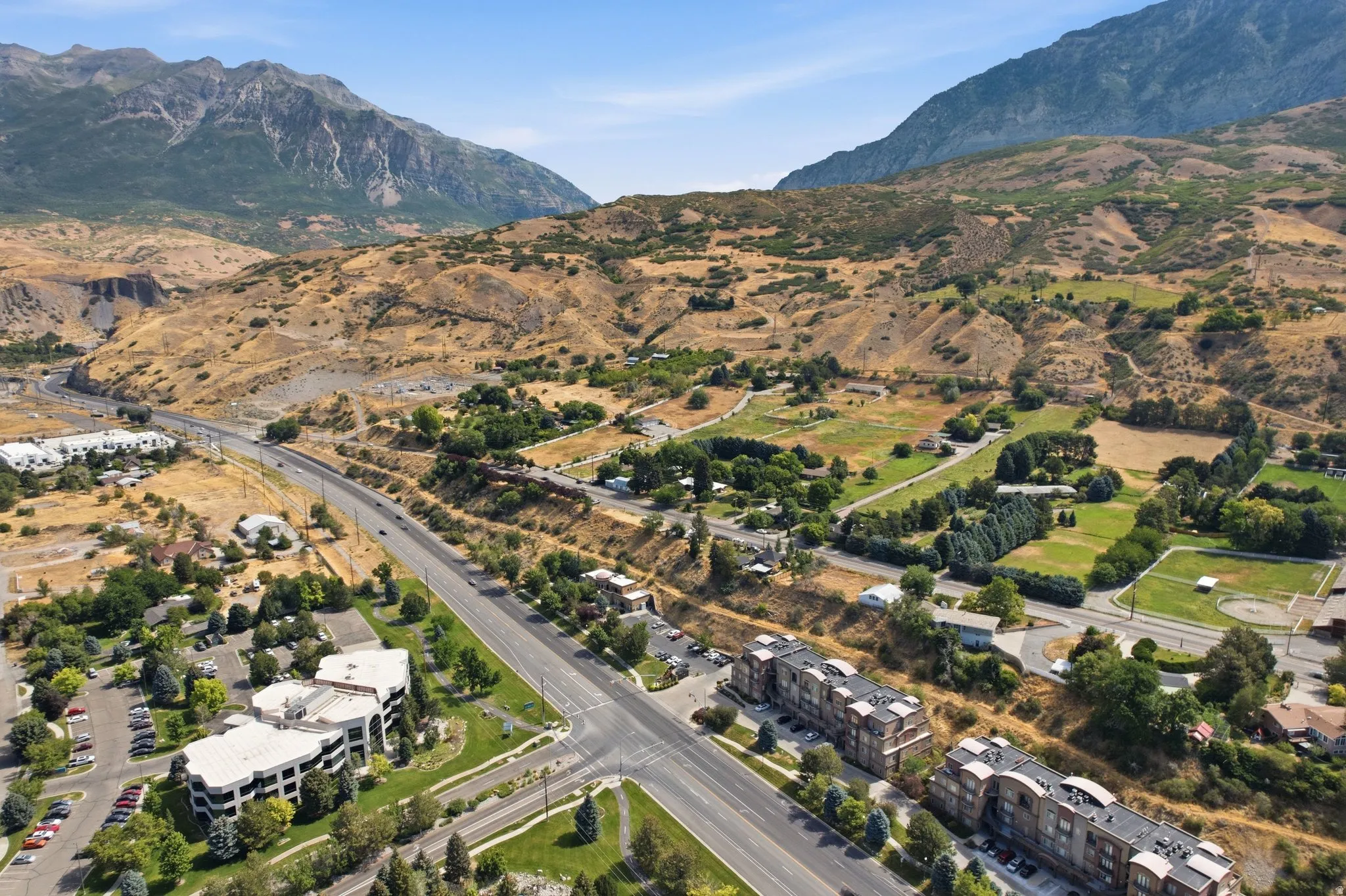 Expansive mountain backdrop framing a diverse landscape with residential and commercial structures