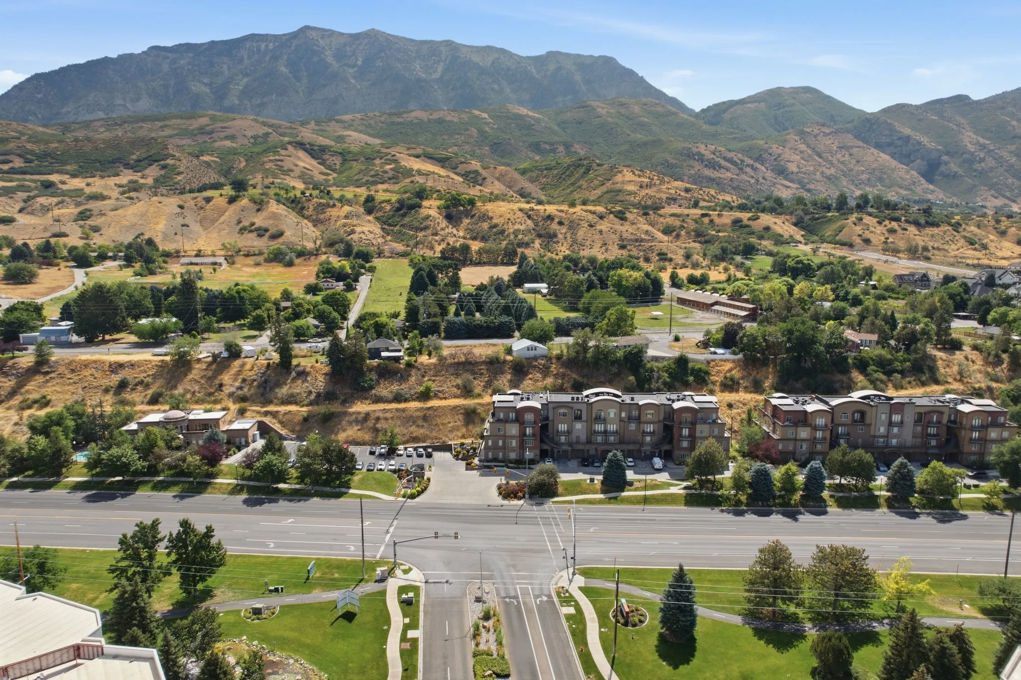 Terraced housing development featuring multiple residential buildings with mountain backdrops