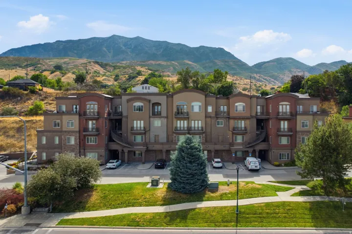 Multi-level condominium building featuring varied exterior finishes including stucco and stone accents