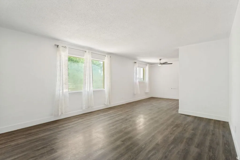 Spacious interior featuring wood-finish flooring, white walls, and multiple windows