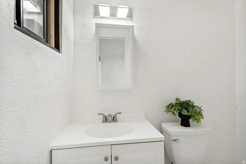 Bathroom vanity with integrated sink, brushed nickel faucet, and white cabinetry
