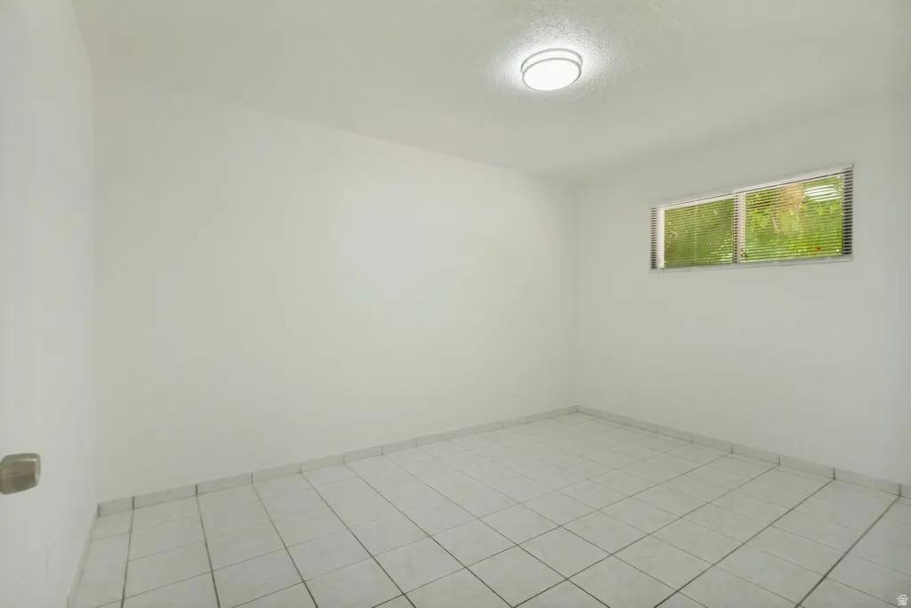 Light-filled interior featuring white walls and a white tile floor