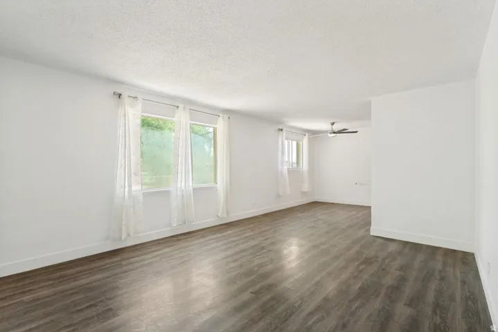 Spacious interior featuring wood-finish flooring, white walls, and multiple windows