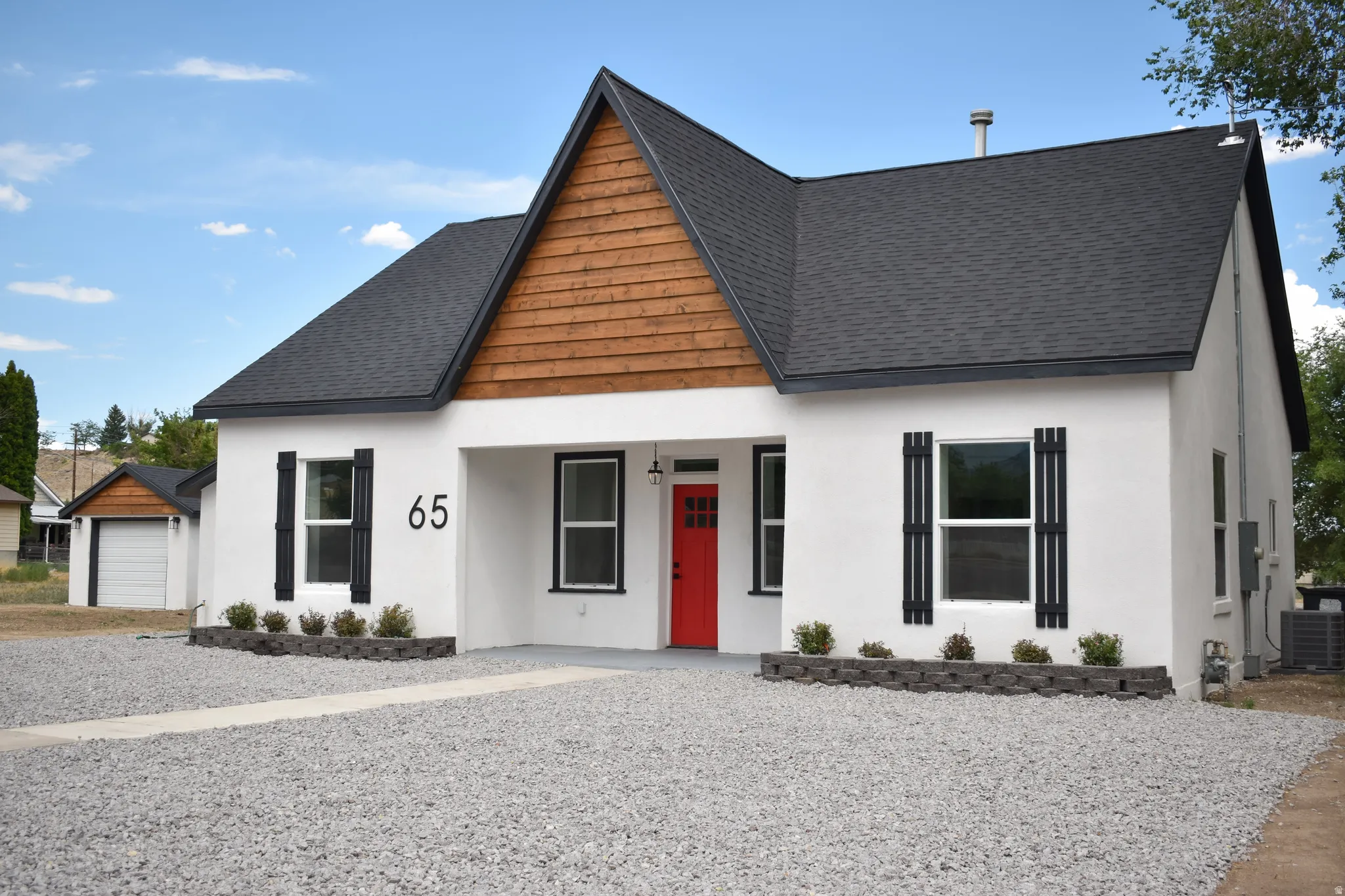 White stucco exterior with a striking red front door and black window trim