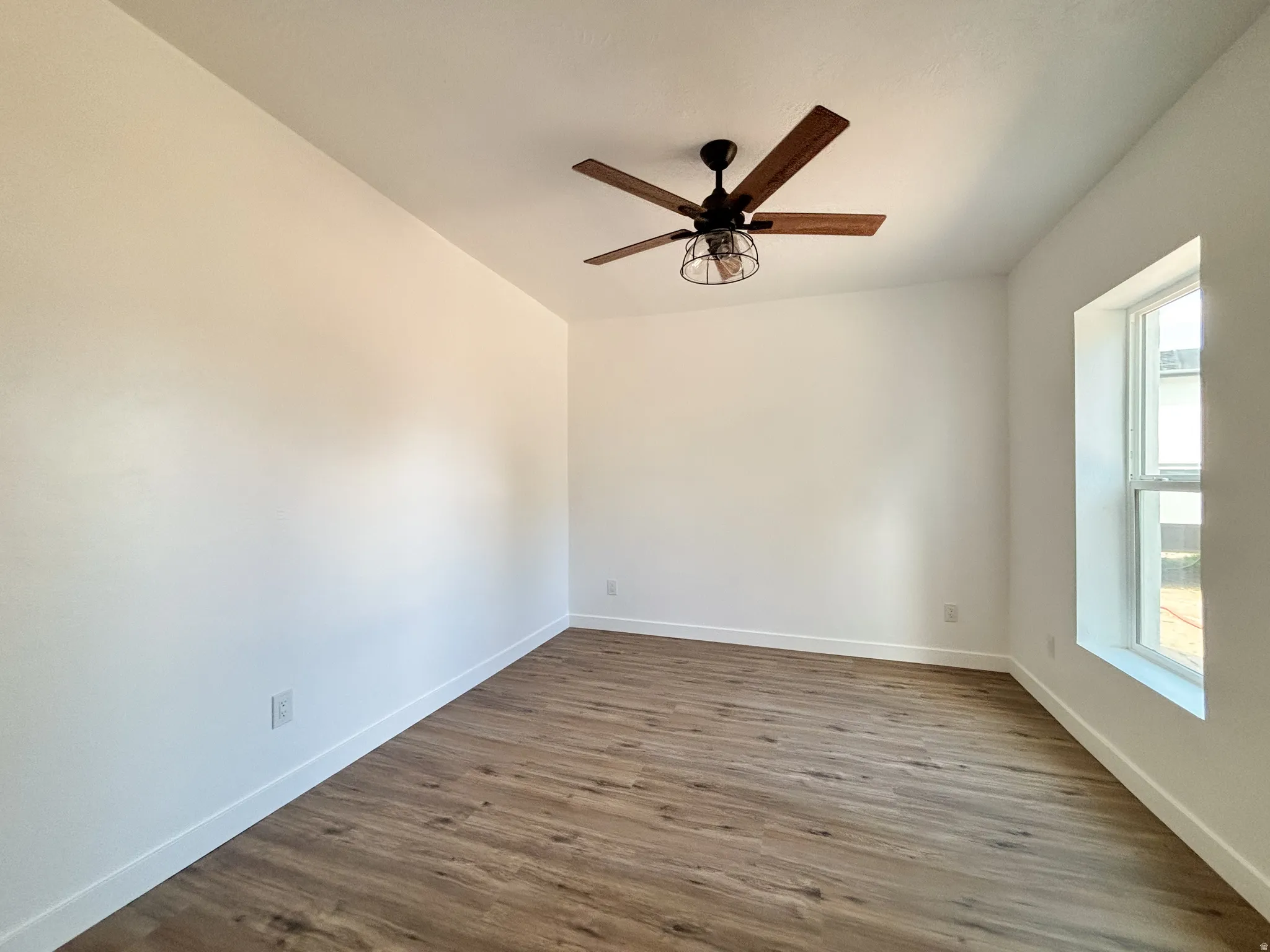 Room featuring wood-finish flooring, a contemporary ceiling fan, baseboard molding, and a single window