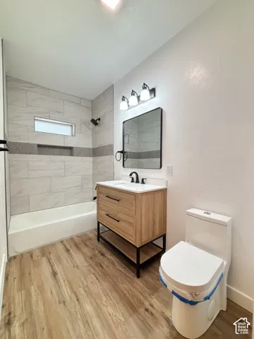 Modern bathroom featuring wood-finish flooring and a contemporary vanity with black hardware