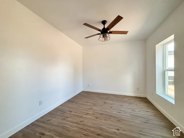 Room featuring wood-finish flooring, a contemporary ceiling fan, baseboard molding, and a single window