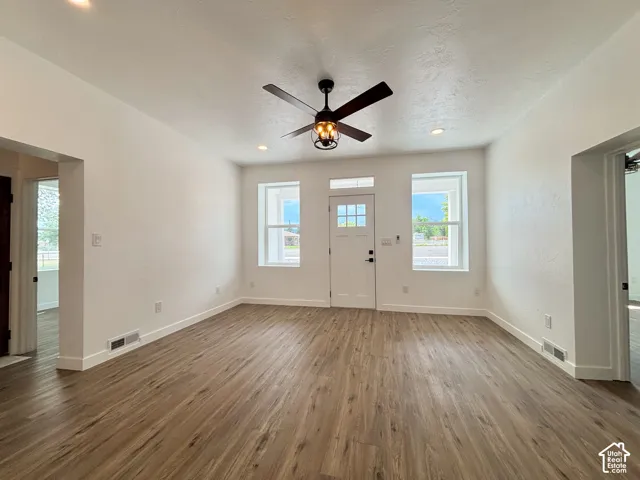 Spacious entry area featuring wood-finish flooring, recessed lighting, and a ceiling fan with integrated lighting