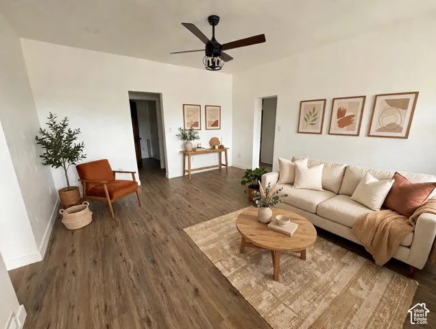 Living area featuring wood-finish flooring, recessed lighting, and a matte black ceiling fan with an integrated cage light fixture