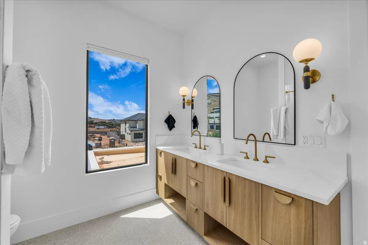 Double vanity with wood-finish cabinetry, white countertops, and integrated sinks