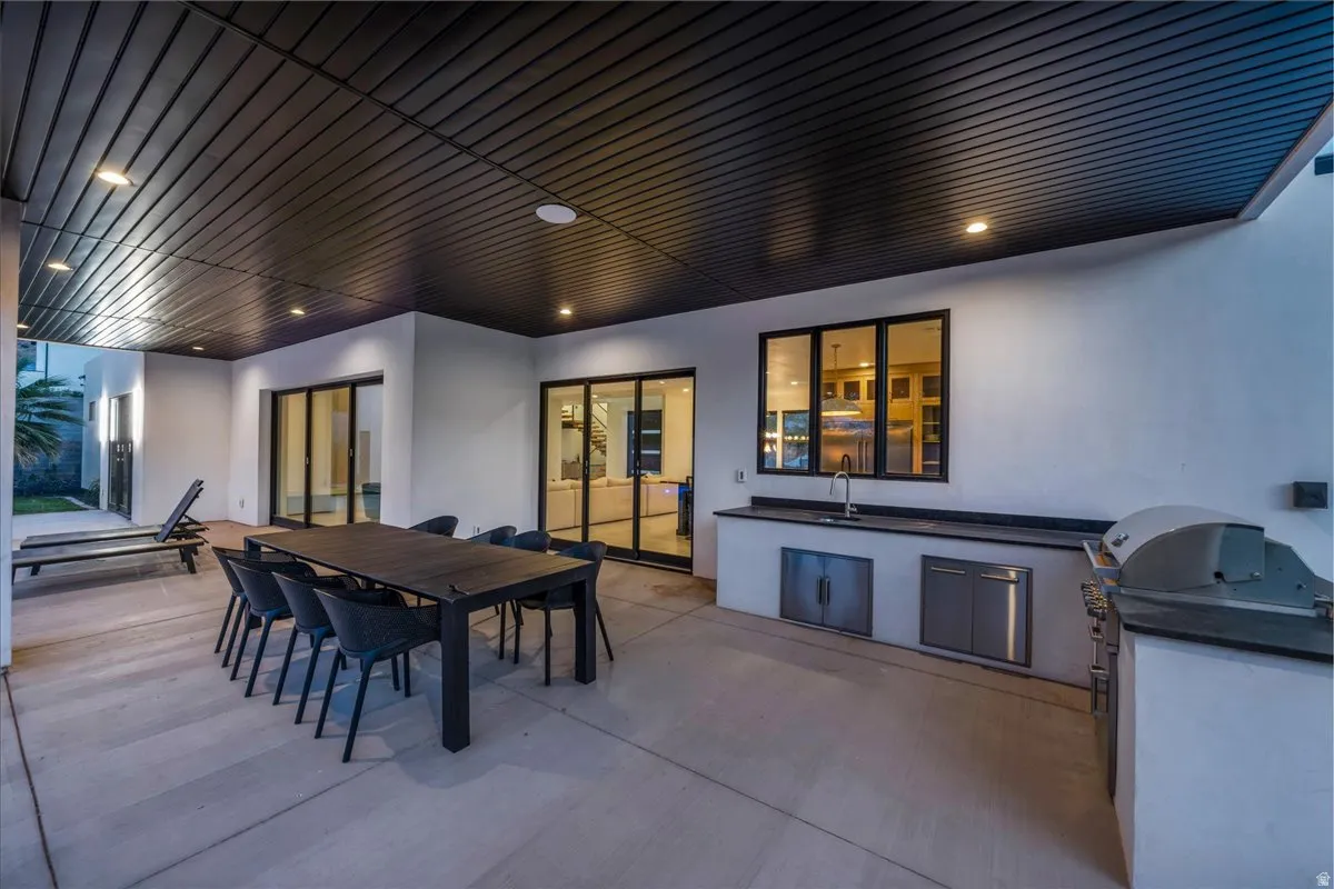 Covered patio featuring a slatted ceiling with recessed lighting