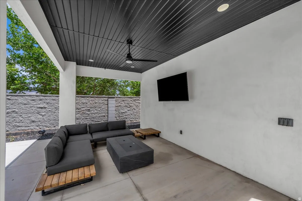 Covered patio featuring a black corrugated ceiling with recessed lighting and a ceiling fan