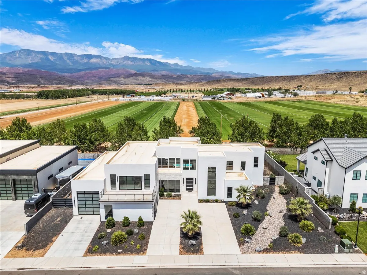 Modern white stucco residence with a flat roofline, featuring multi-pane windows and a distinct architectural design