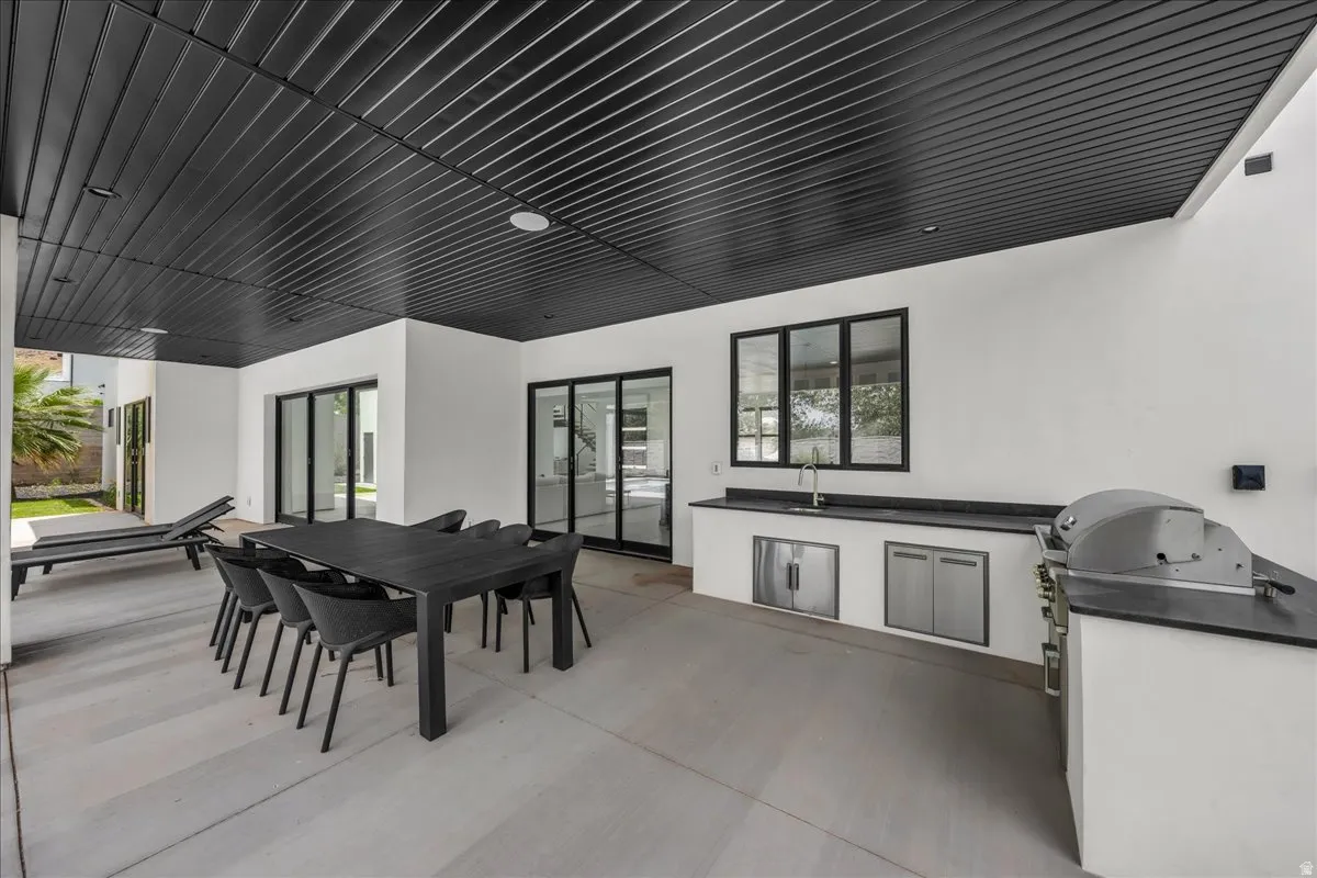 Expansive covered patio featuring a black slatted ceiling and recessed lighting