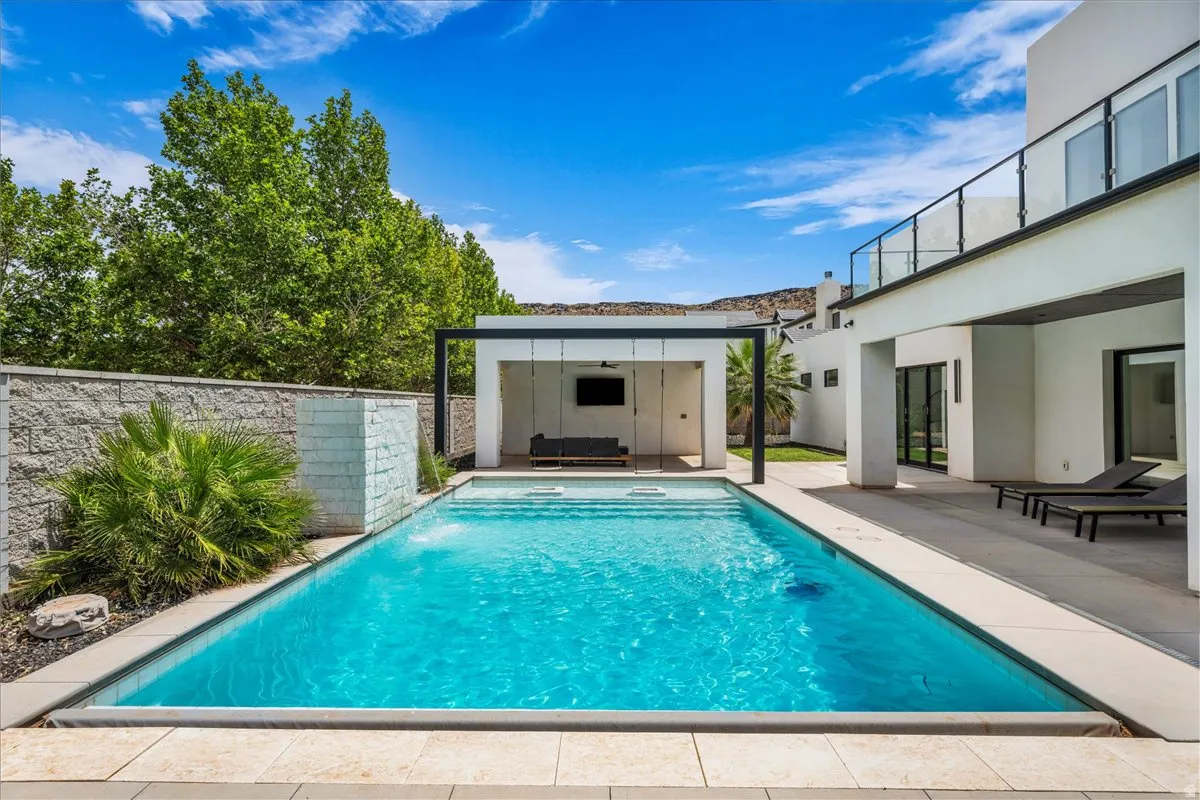 Swimming pool with integrated steps, surrounded by light-toned paving stones