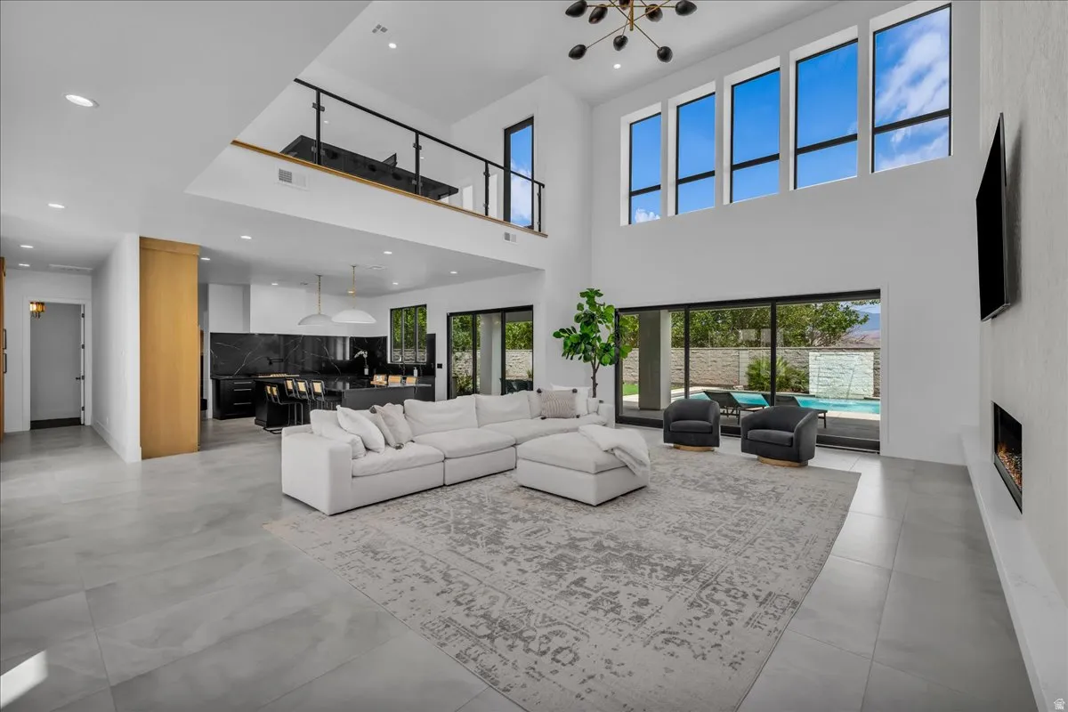Spacious living area featuring high ceilings, a loft overlooking the main space, and large windows
