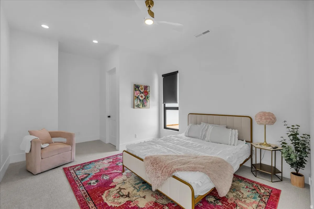 Bright interior space featuring recessed lighting, a ceiling fan, and a large window with a roll-down shade