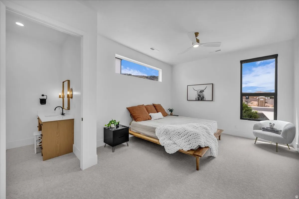 Contemporary room featuring light-colored carpeting and a ceiling fan
