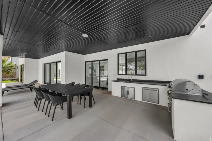 Expansive covered patio featuring a black slatted ceiling and recessed lighting