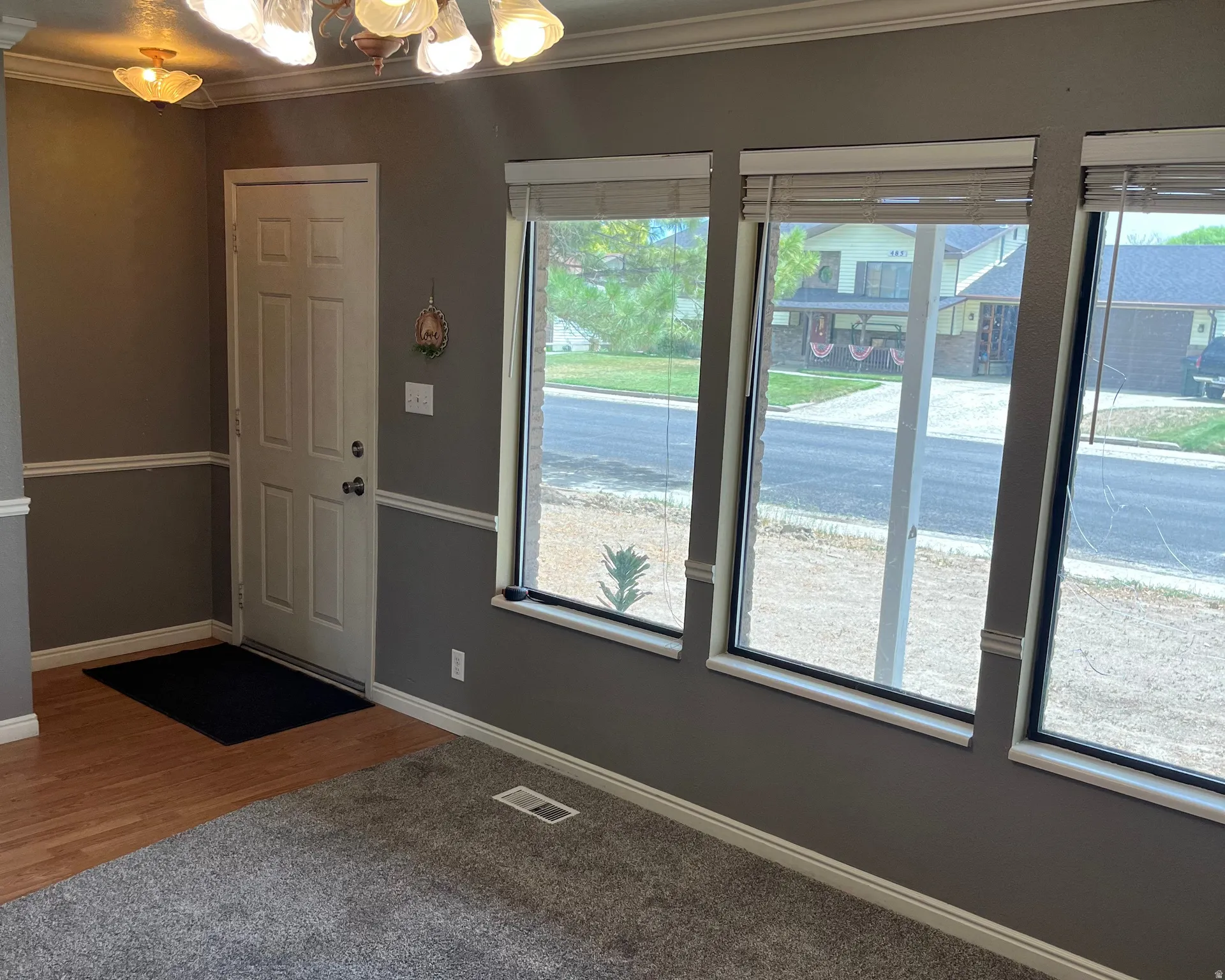 Entryway featuring a paneled door, decorative wall trim, and wood-finish flooring