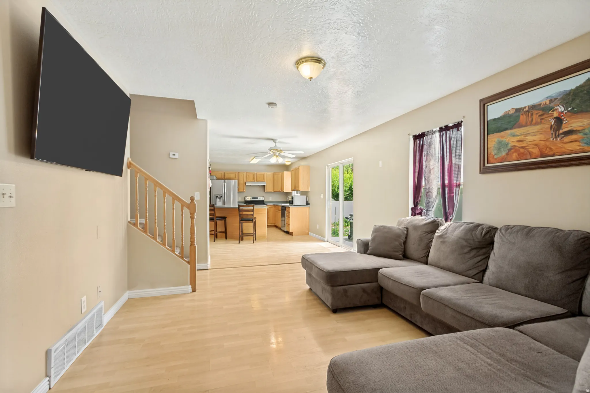 Open-concept living area with light wood-finish flooring