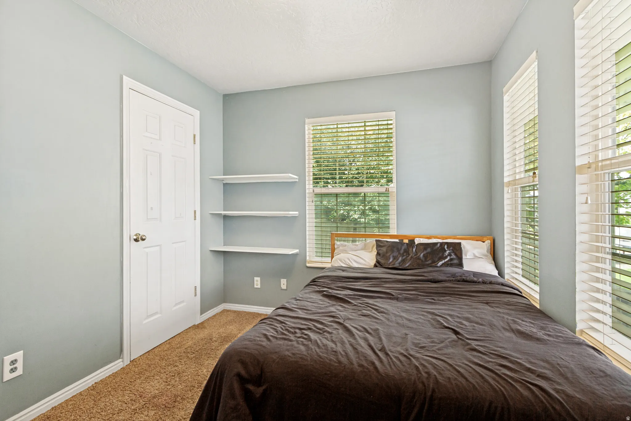 Neutral-toned carpeting complements light blue wall paint