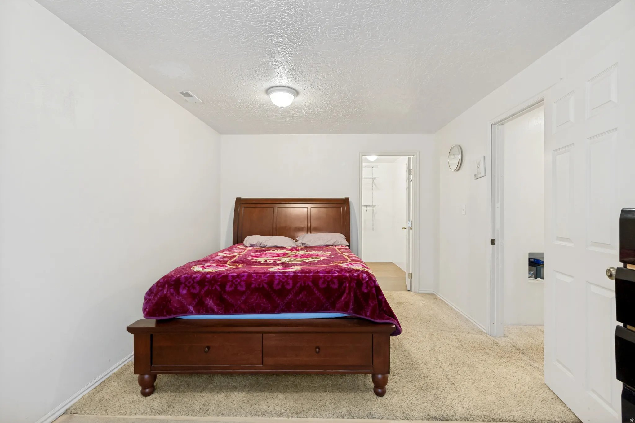 Carpeted room with white walls, a flush-mount ceiling light, and a solid white door