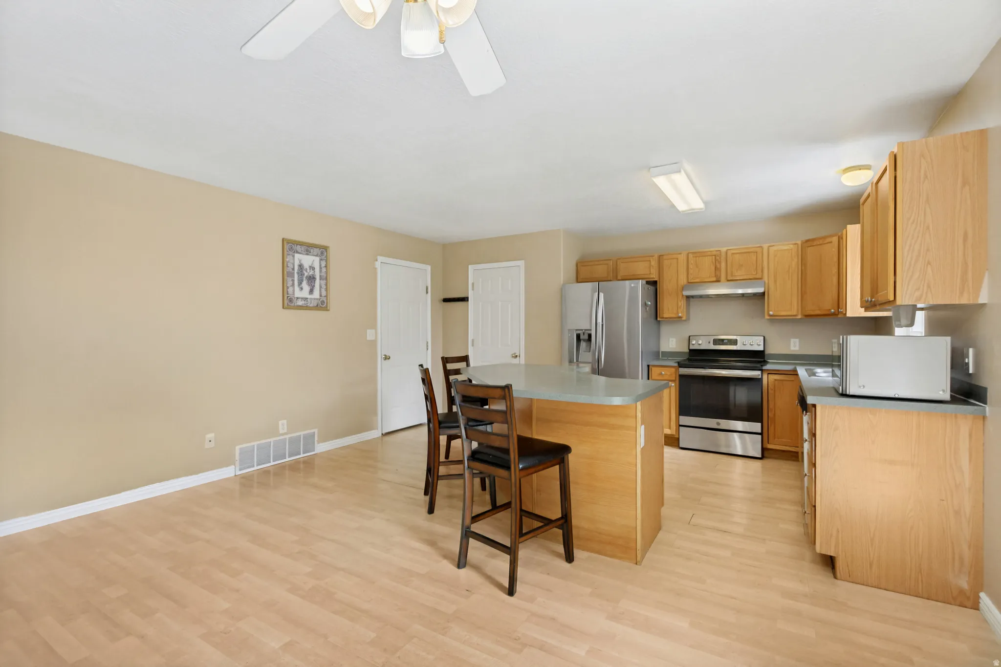 Open-concept kitchen and dining area featuring wood-finish flooring