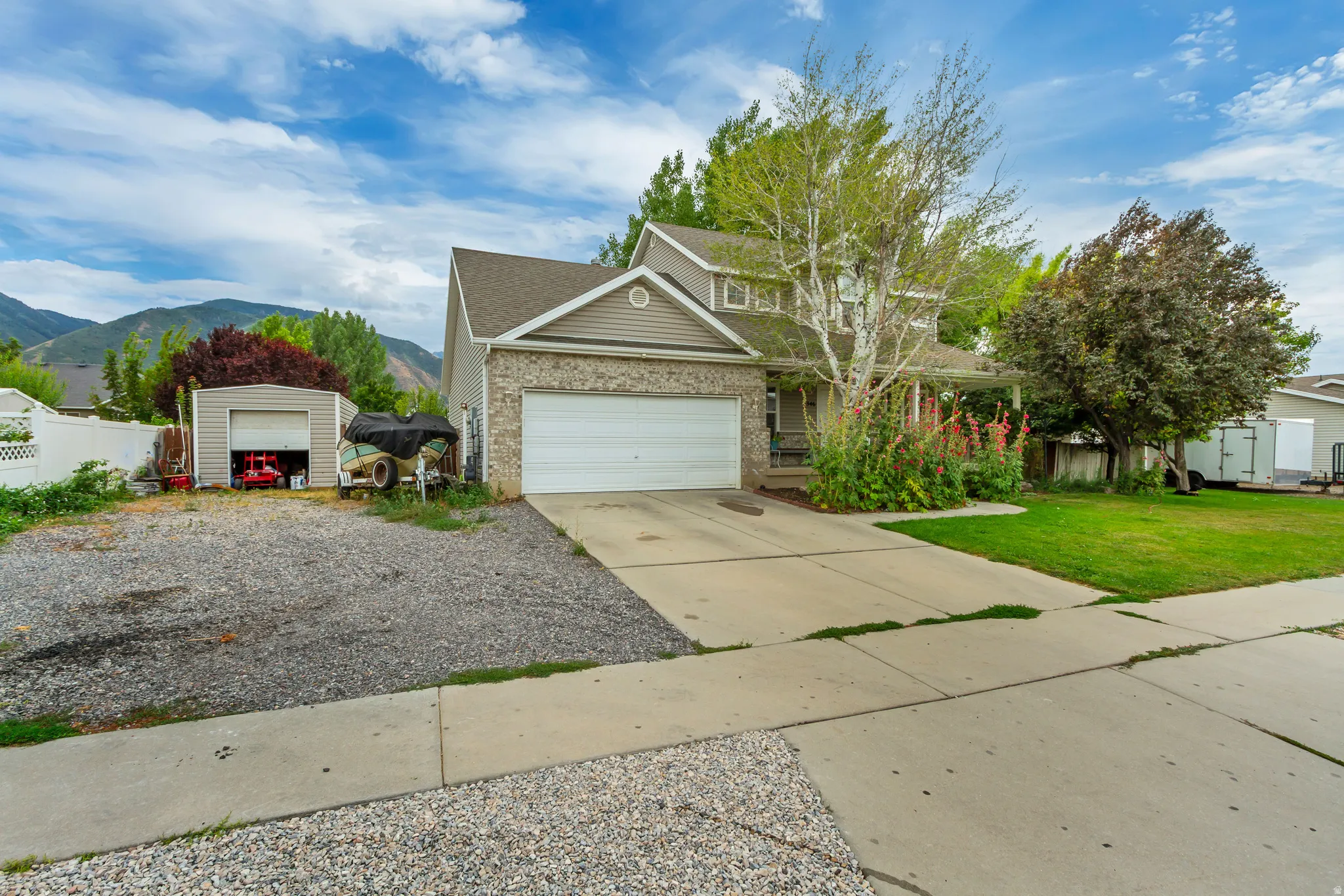 Two-story home featuring a combination of brick and siding, an attached two-car garage, and a concrete driveway