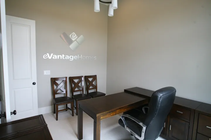 Spacious room with light neutral wall paint, white panel door with dark hardware, and light-colored carpet flooring