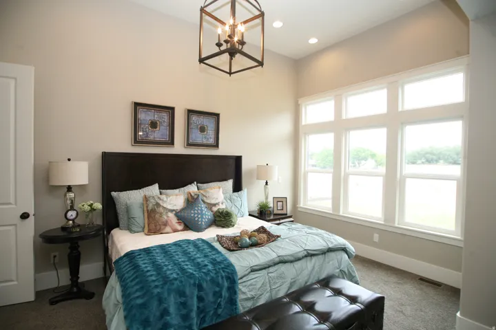 Spacious room featuring multiple large windows, recessed lighting, and a prominent open-cage chandelier