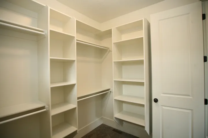 Built-in white shelving and hanging rods create a versatile closet system, this home has storage in all the closets