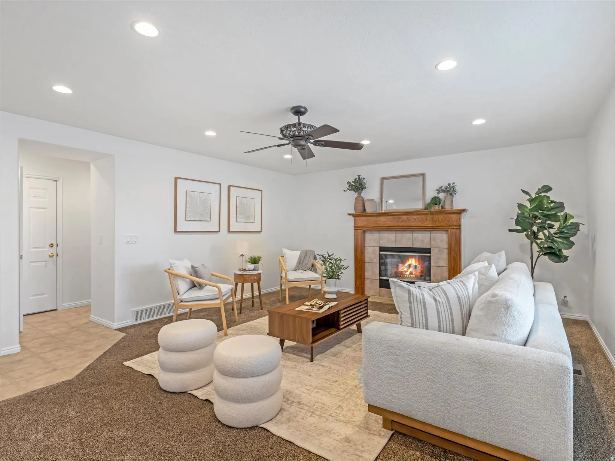 Living area featuring recessed lighting, a ceiling fan, and a fireplace with a wood mantel and tile surround