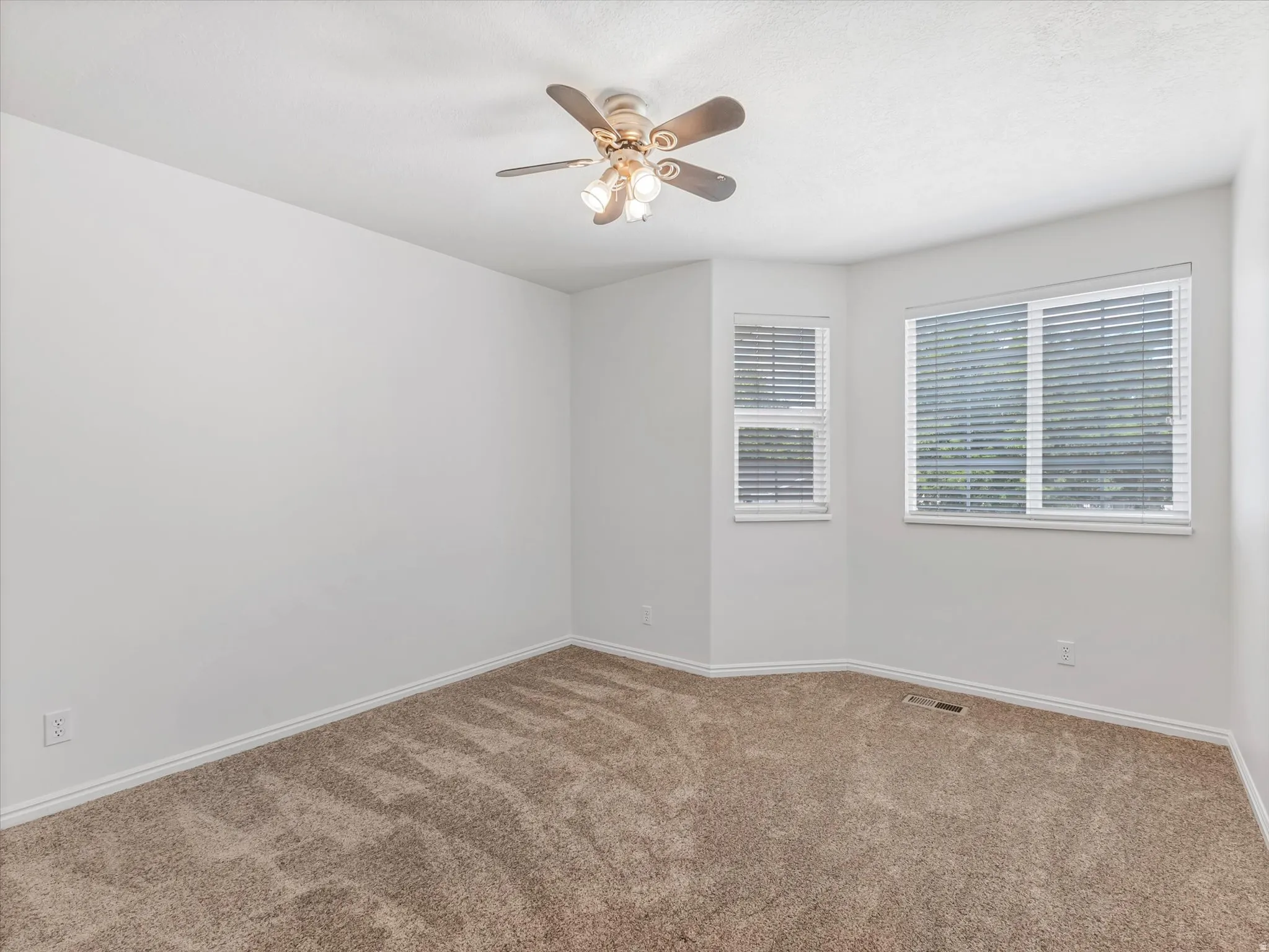 Bedroom 3-Neutral tone wall finishes, ceiling fan with integrated lighting, multiple windows with horizontal blinds, and carpeting