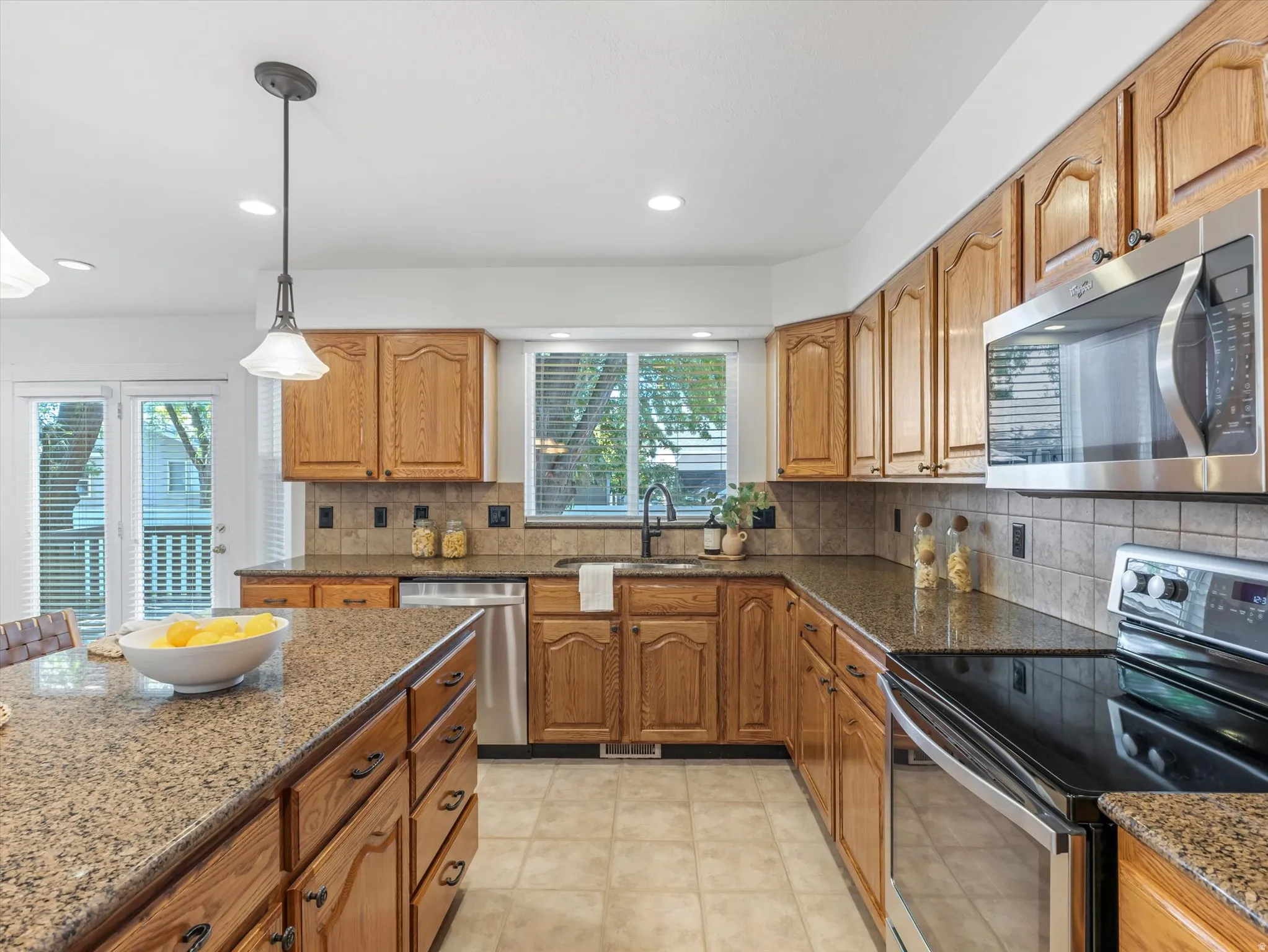 Contemporary kitchen with wood cabinetry and granite-style countertops