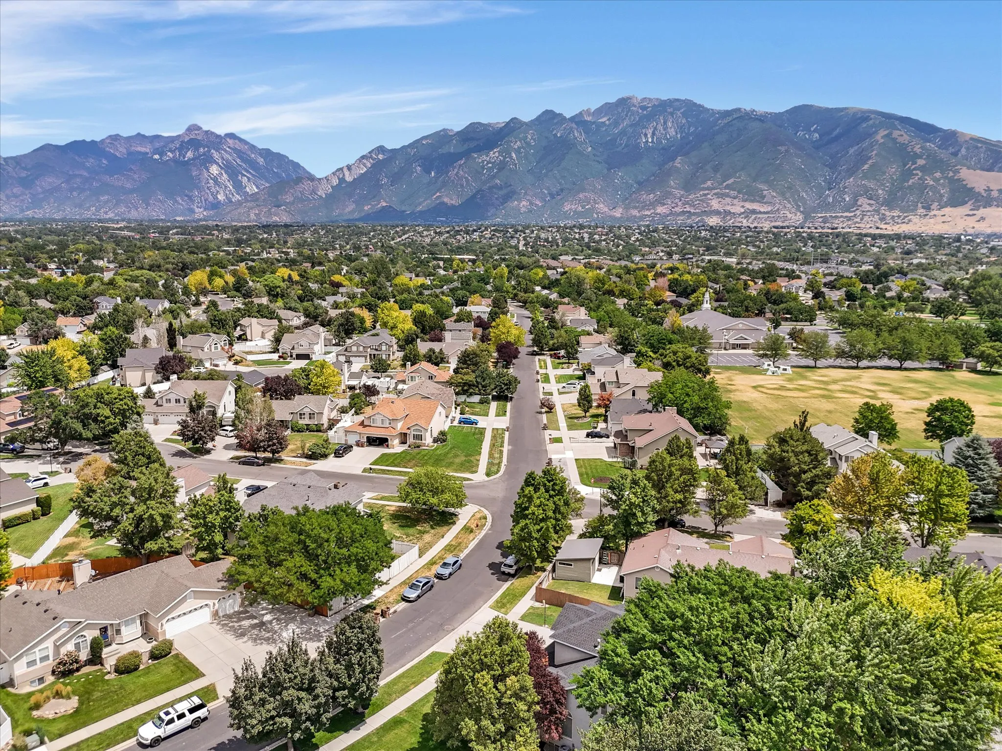Expansive suburban landscape featuring established residential streets, mature trees, and mountainous terrain
