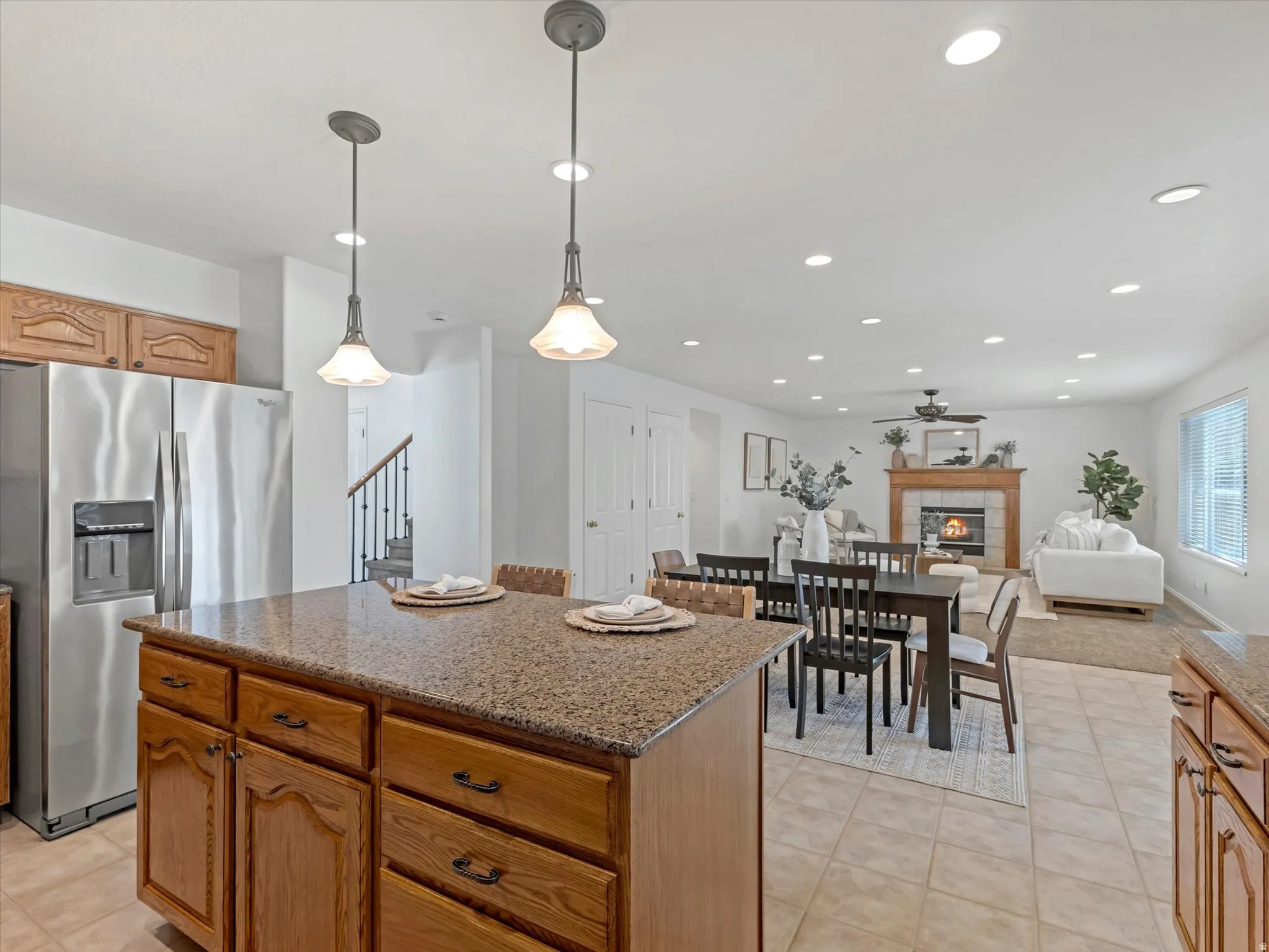 Kitchen island with granite-finish countertop and wood cabinetry and open concept family room